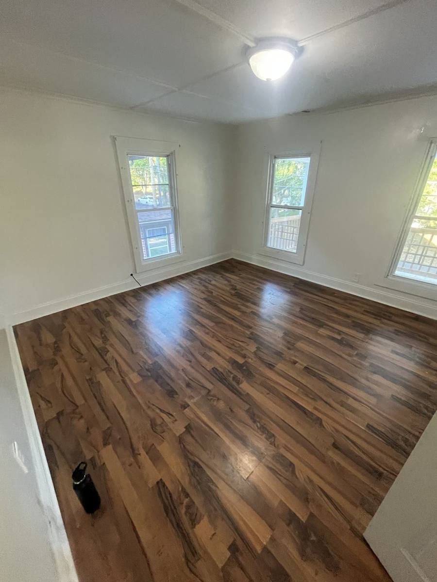 Empty room with hardwood floors and three windows