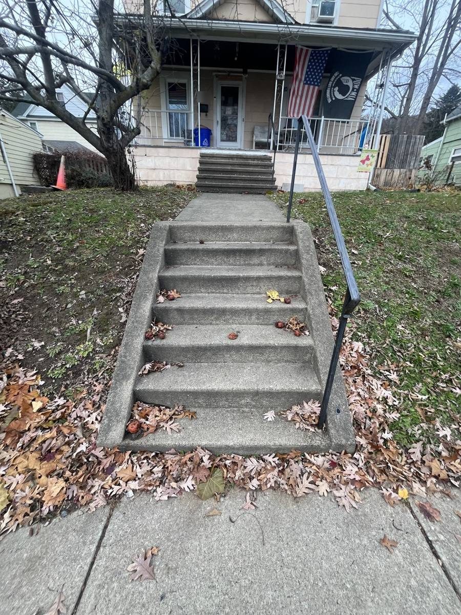 Concrete front steps leading up to the porch