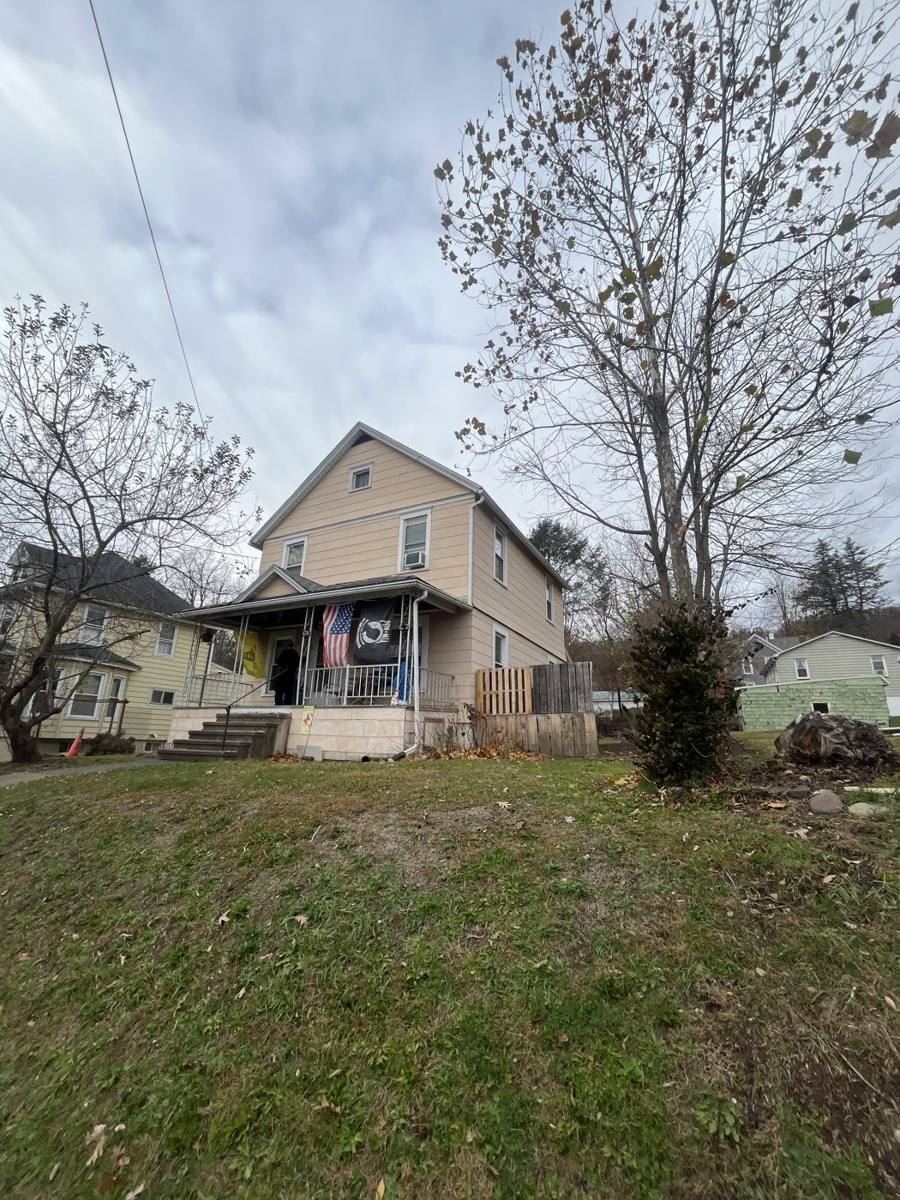 Two-story house with a covered front porch on the West Side of Binghamton, NY, in late fall